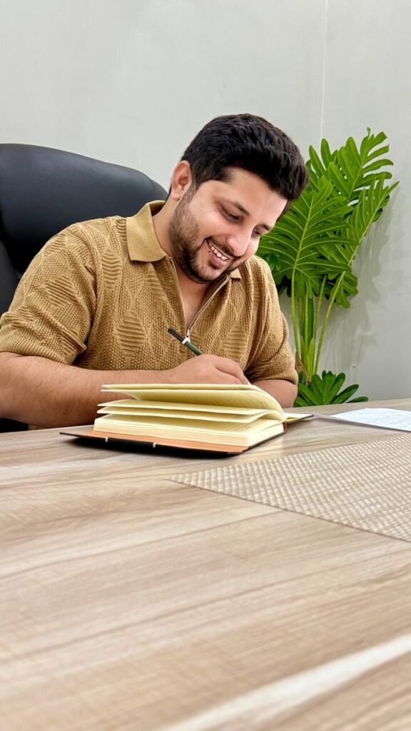 Awais Bukhari writing project notes at his desk